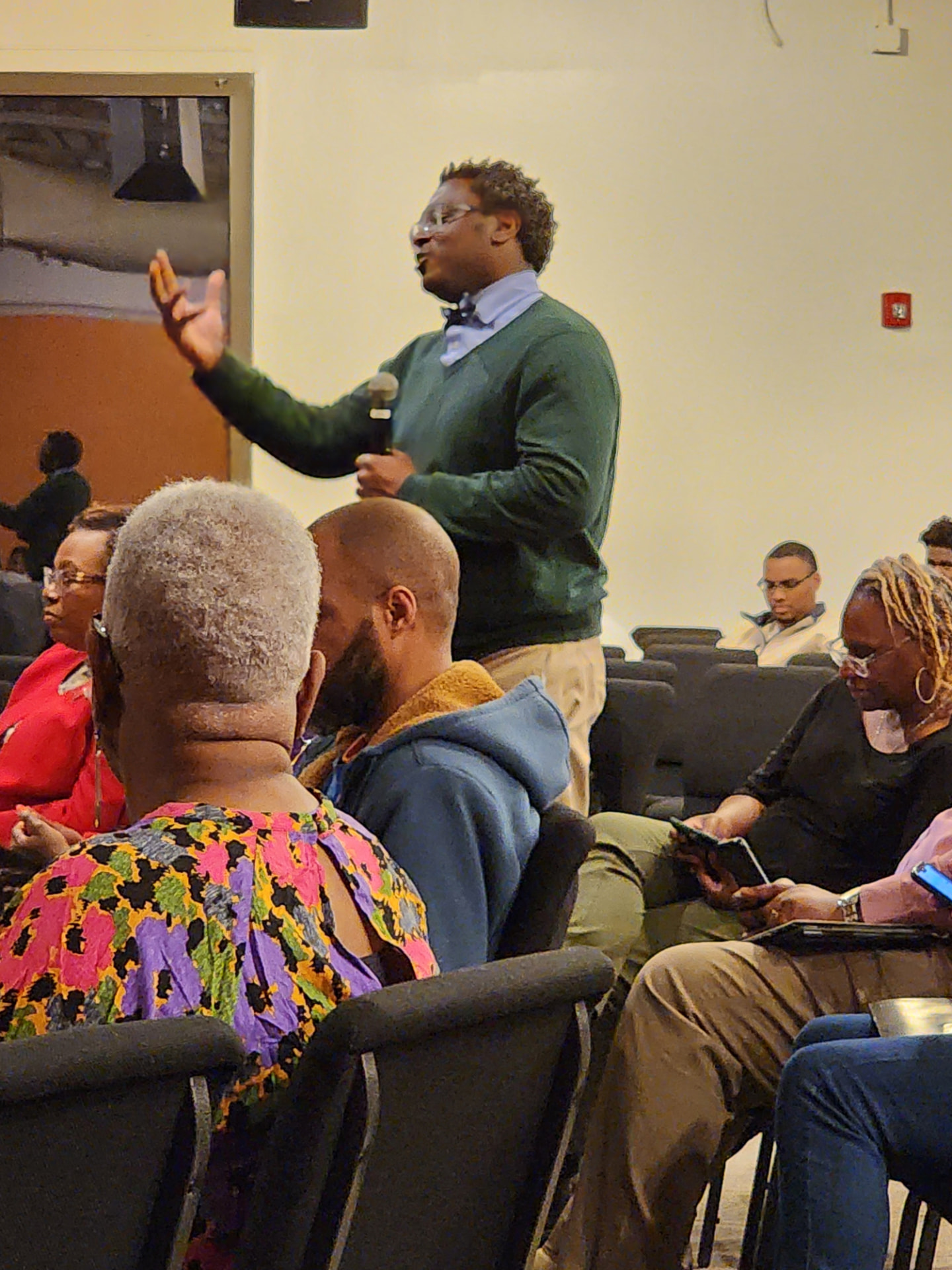 An attendee standing to ask a question during an open-floor discussion